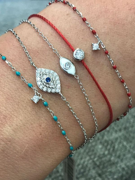 Sterling silver chain bracelet with turquoise beads and a hanging CZ charm in the centre.